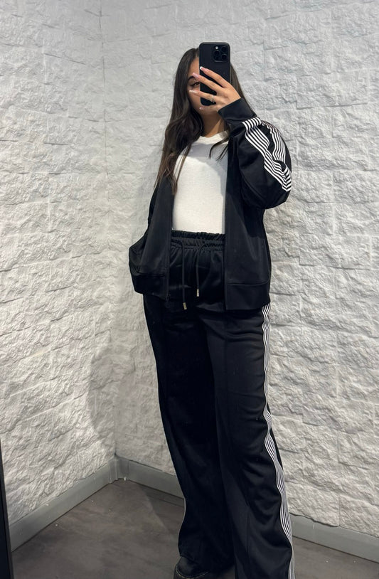 Completo nero in tuta con giacca zip e pantalone palazzo con bande