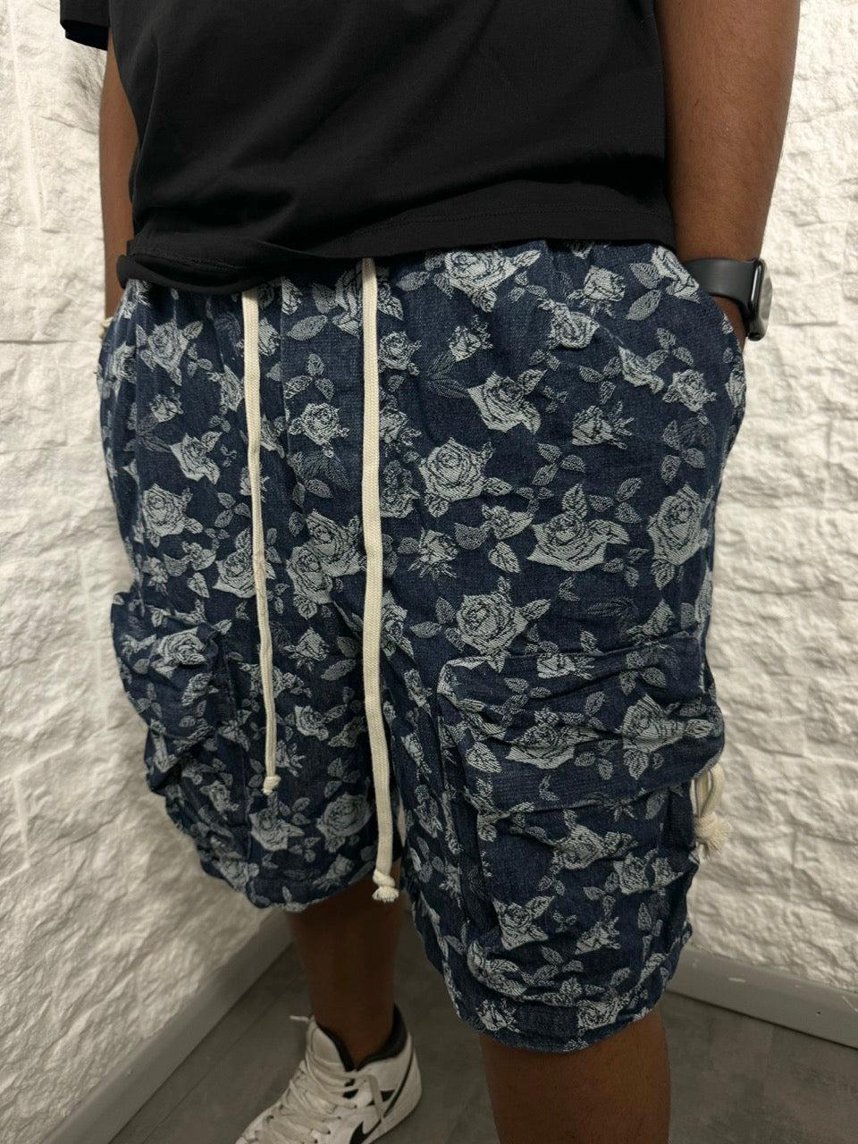 Jeans cargo in denim blu con tasca frontale a zip e rose ricamate
