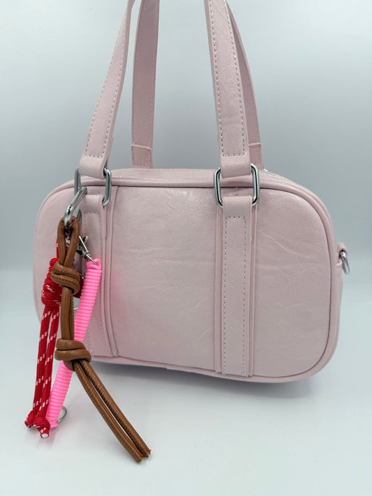Borsa bauletto rosa chiaro in ecopelle con charm colorati