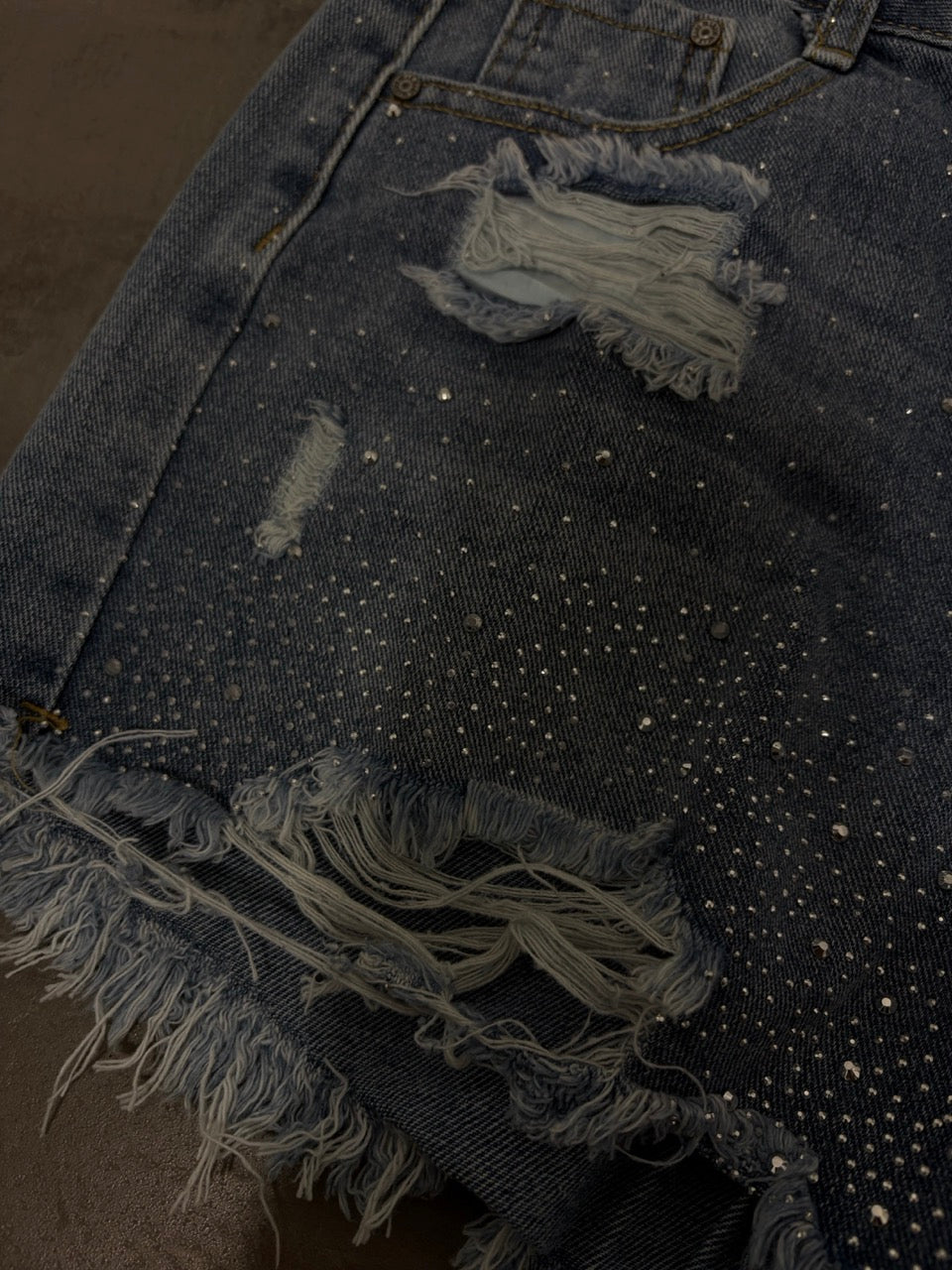 Short in denim blu con brillantini e strappi