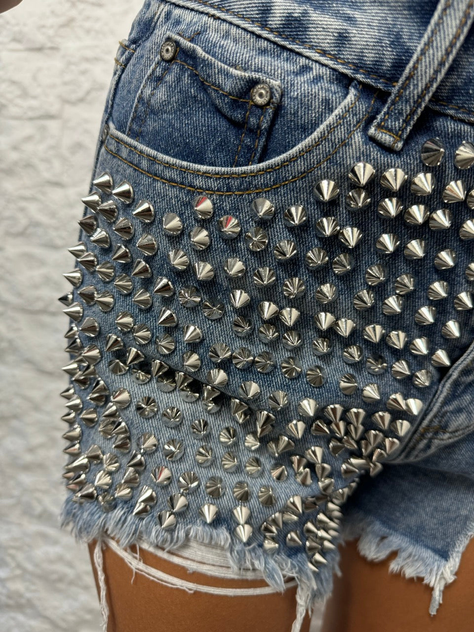 Short blu in denim con borchie