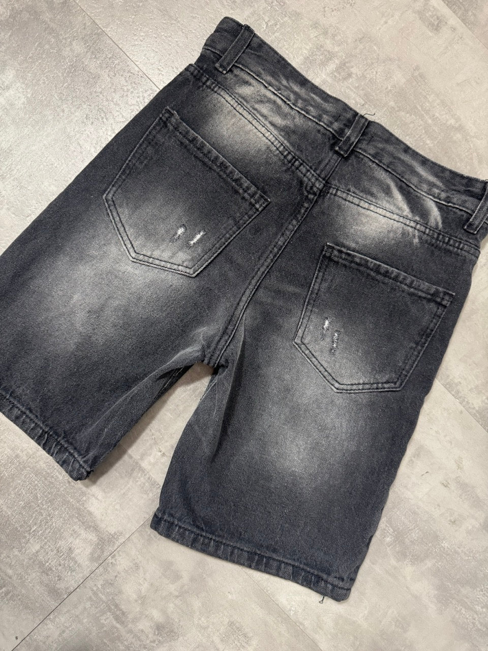 Pantaloncino bermuda grigio in denim con strappi e schizzi di vernice