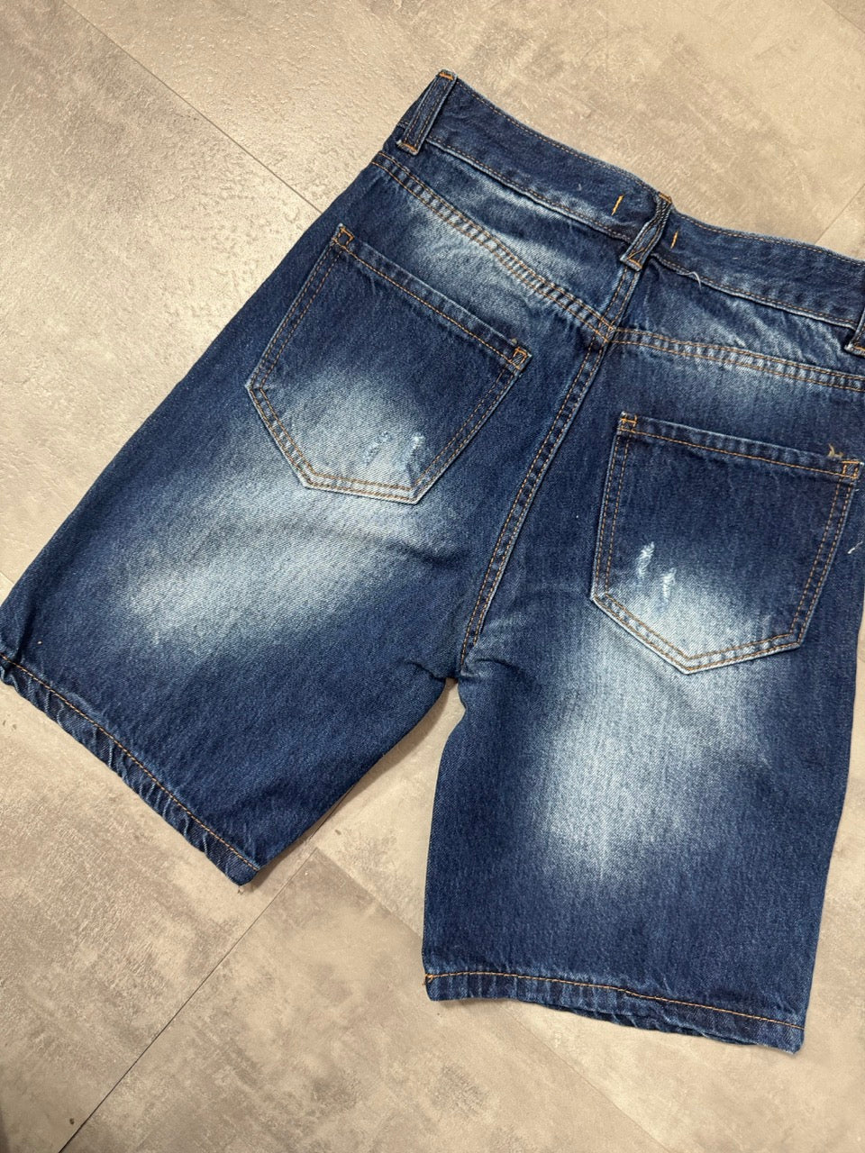 Pantaloncino bermuda blu in denim con strappi e schizzi di vernice