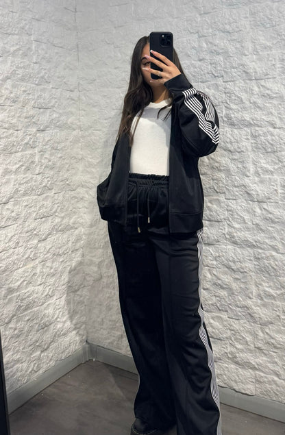Completo nero in tuta con giacca zip e pantalone palazzo con bande