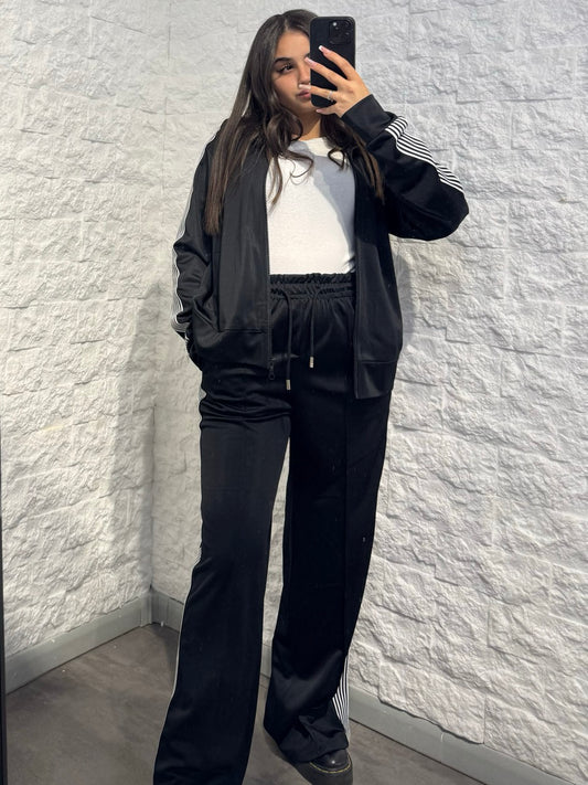 Completo nero in tuta con giacca zip e pantalone palazzo con bande