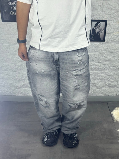 Jeans baggy grigio in denim con strappi e orlo sfrangiato