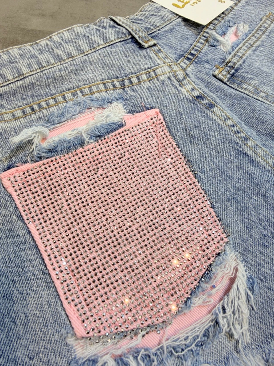 Jeans shorts azzurro chiaro slavato sfrangiato con tasca rosa strass 6-16 anni