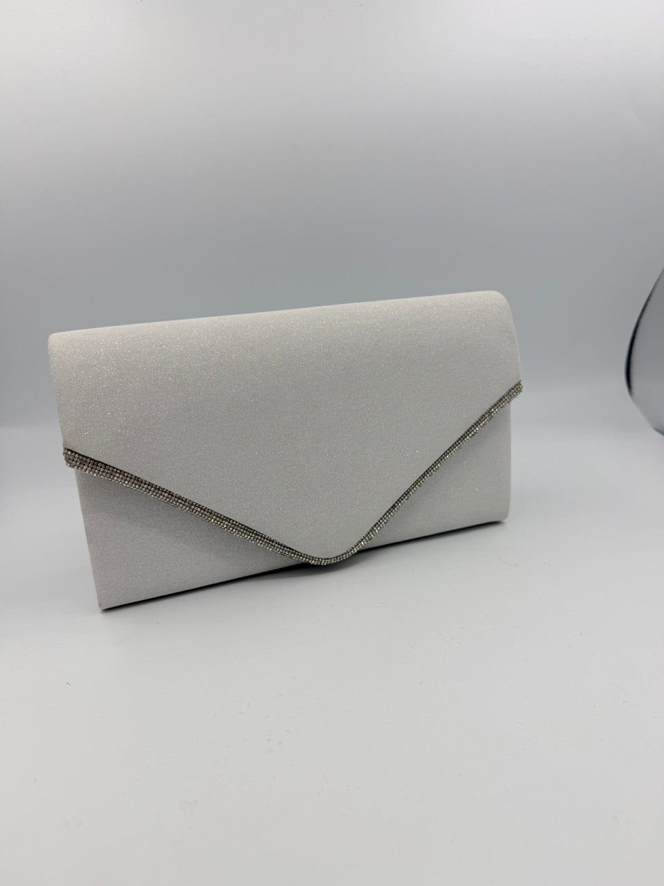 Pochette bianca brillantinata con patta e profili strass