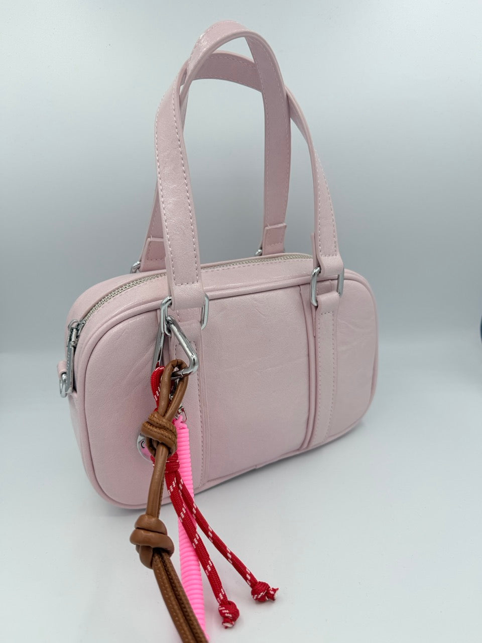 Borsa bauletto rosa chiaro in ecopelle con charm colorati