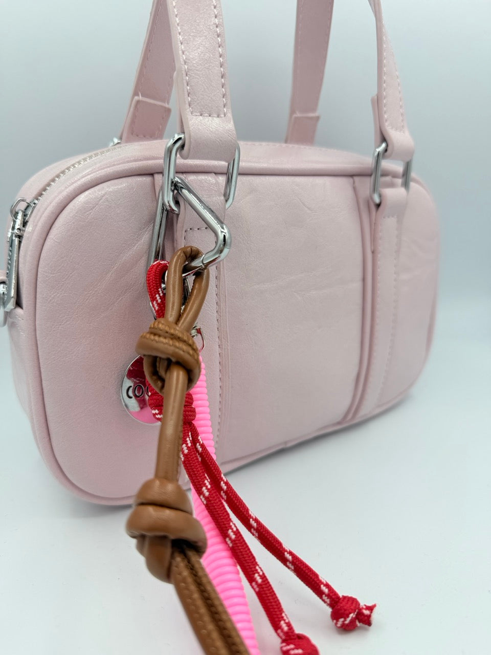 Borsa bauletto rosa chiaro in ecopelle con charm colorati