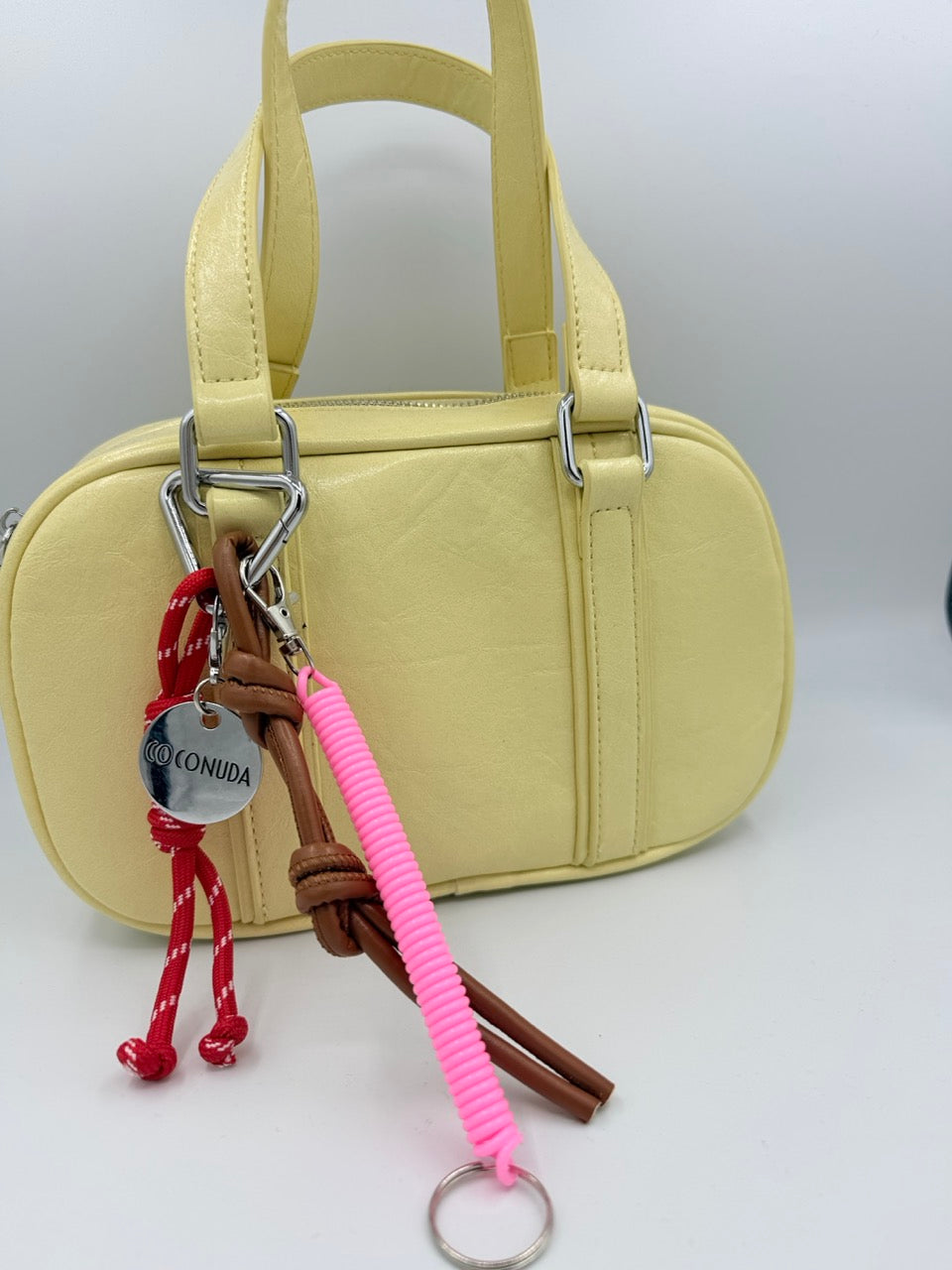 Borsa bauletto giallo chiaro in ecopelle con charm colorati