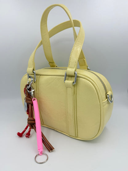 Borsa bauletto giallo chiaro in ecopelle con charm colorati