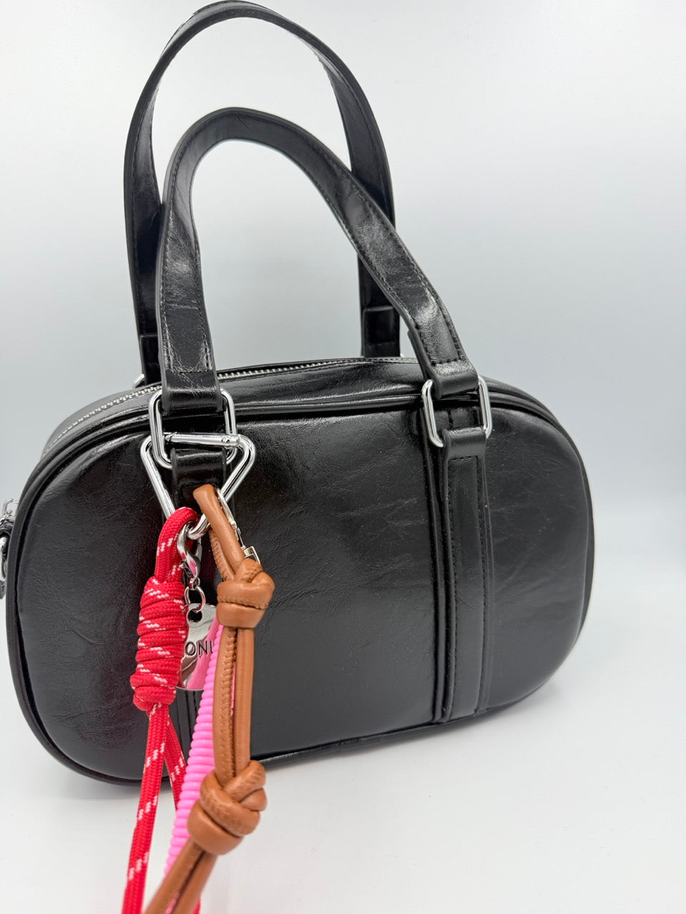 Borsa bauletto nera lucida in ecopelle con charm colorati