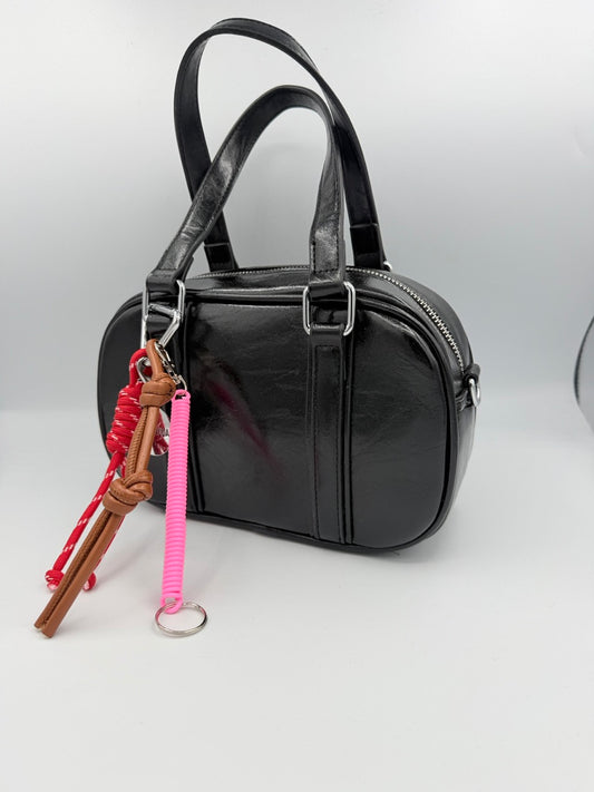 Borsa bauletto nera lucida in ecopelle con charm colorati
