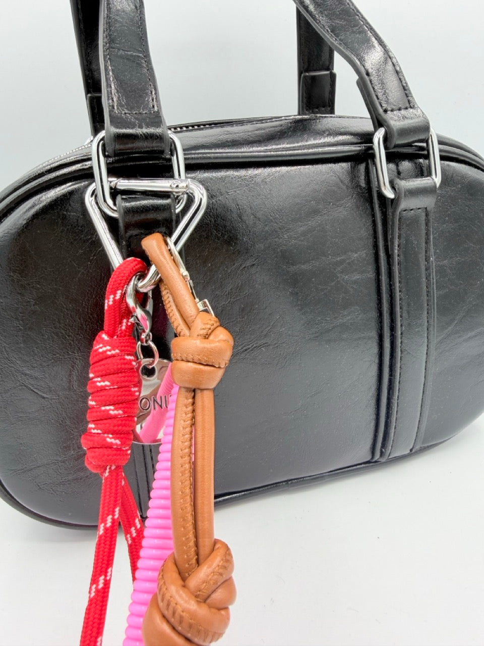 Borsa bauletto nera lucida in ecopelle con charm colorati