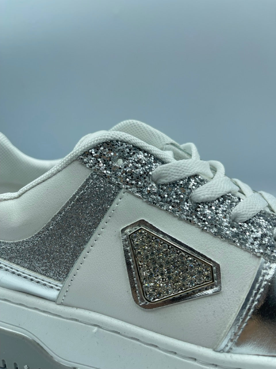 Sneakers bianche con inserti glitter argento e dettaglio gioiello