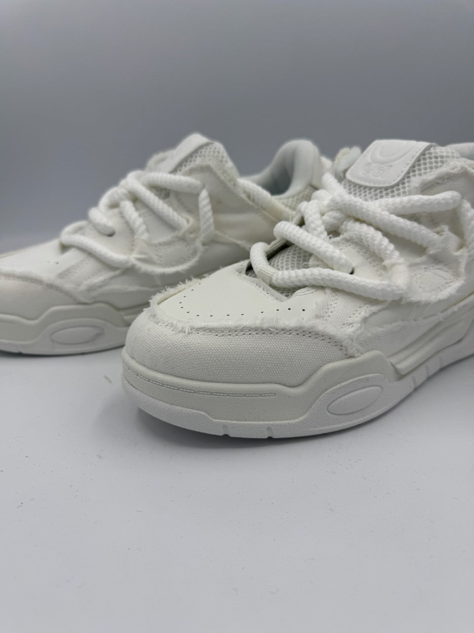 Sneakers bianche con lacci maxi e dettagli effetto rovinato